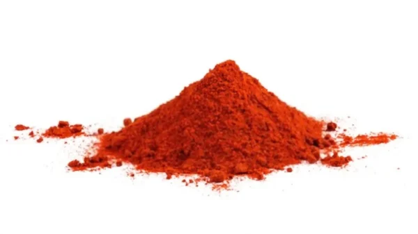 A small mound of finely ground, bright red-orange powder labeled "Paprika" is centered on a white background. The powder appears slightly textured and resembles a culinary spice, with some particles scattered around the base of the mound, creating a tempting sight for B2B Paprika suppliers.