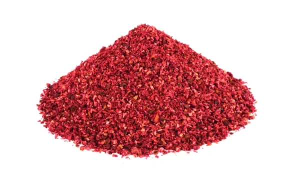 A mound of vibrant, natural Sumac is presented against a white background, its finely ground texture and bright color hinting at a rich, potentially spicy seasoning. This culinary staple is commonly used to enhance flavor and add heat to various dishes. Ideal for those seeking authentic, bold taste in their Sumac purchases.