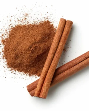 Three Cinnamon sticks and a pile of ground Cinnamon are displayed on a white background.
