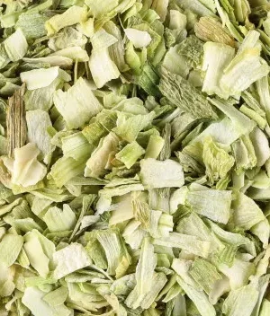 A close-up image of a bowl filled with dried, chopped premium quality Leek. The Leek pieces are in varying shades of green and white, showcasing their dehydrated texture. The small, irregularly shaped pieces hint at their use in cooking or seasoning.